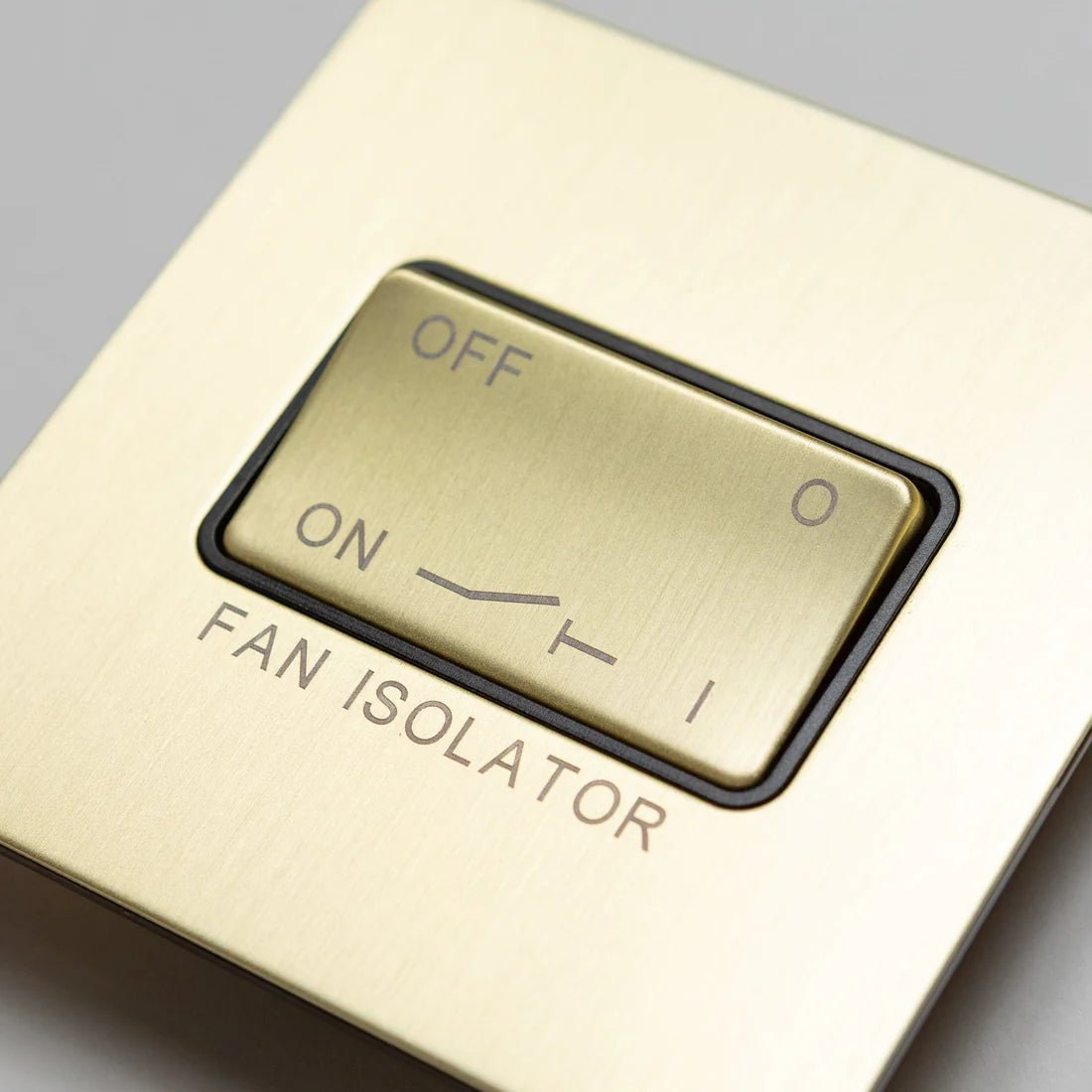 Brass bee Satin Brass Switches and Sockets in a straight knurled design, featuring an ON/OFF toggle for a fan isolator, designed with engraved text and a smooth brass finish.