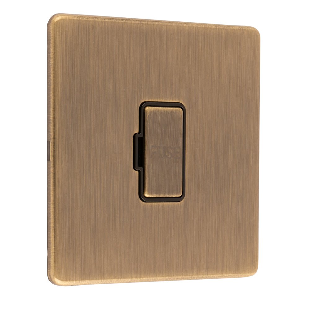 Eurolite Concealed 3mm Unswitched Fuse Spur in antique brass, featuring a simple rectangular plate with a push-button mechanism in the center, designed for electrical safety and control.