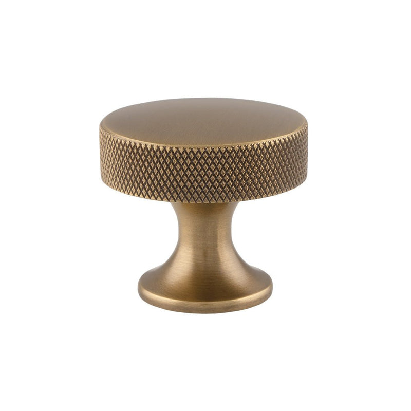 Alexander & Wilks Berlin Knurled Cupboard Knob in antique brass finish, featuring a textured surface for grip and a round top, mounted on a thick base.