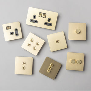 Brass bee Satin Brass Switches and Sockets featuring a straight knurled design, shown in a variety of configurations, highlighting their smooth, metallic finish and contrasting button textures.