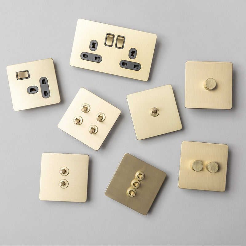 Brass bee Satin Brass Switches and Sockets featuring a straight knurled design, shown in a variety of configurations, highlighting their smooth, metallic finish and contrasting button textures.