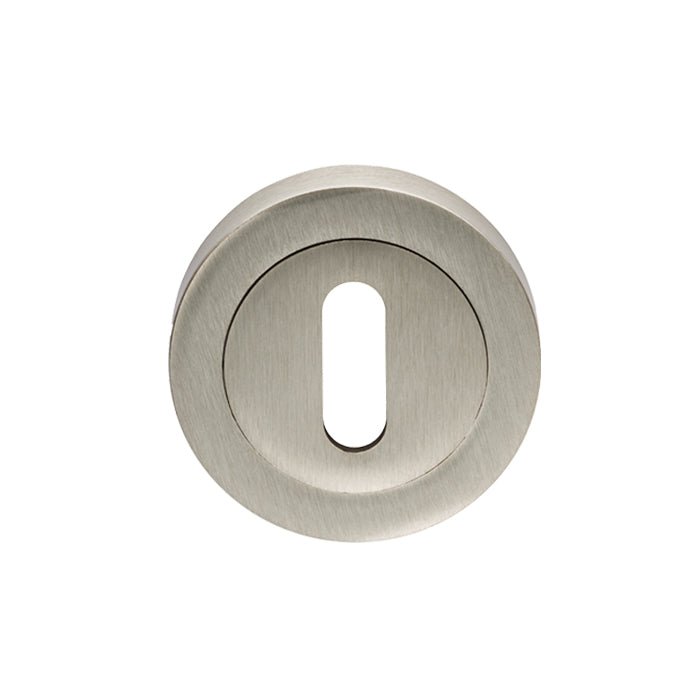 Carlisle Brass Lock Escutcheons in a brushed nickel finish, featuring a circular shape with a narrow keyhole opening, designed for use with door locks.