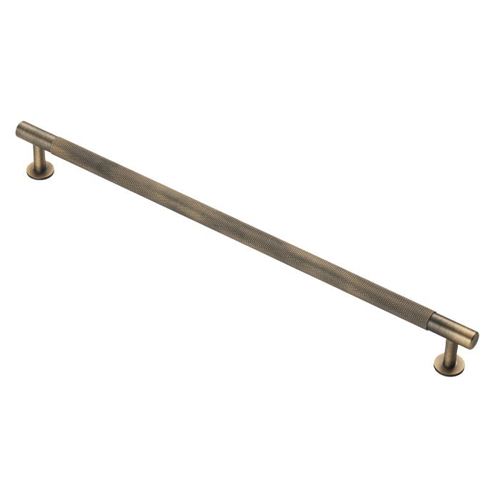 Carlisle Brass Knurled Pull Handle in an antique brass finish, featuring a long straight bar design with knurling along its surface and mounted on two round bases.