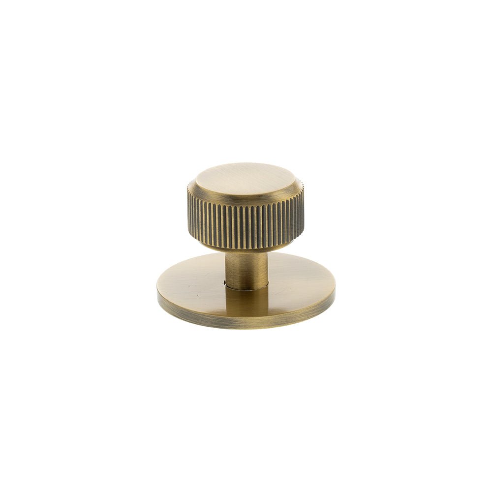 Atlantic Millhouse Brass Battersea Linear Round Cabinet Knob Handle on Backplate features a brushed brass finish with a ribbed design on the knob and a circular backplate, providing a modern accent for cabinetry.