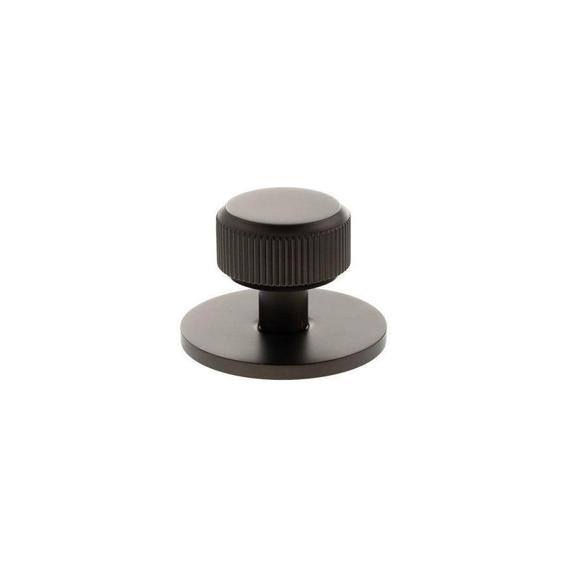 Atlantic Millhouse Brass Battersea Linear Round Cabinet Knob Handle on Backplate is shown in a dark finish, featuring a rounded knob with ribbed details mounted on a circular backplate.