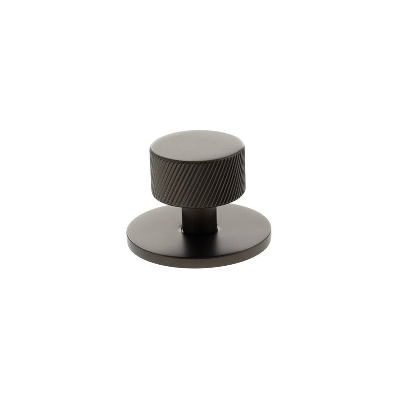 Atlantic Millhouse Brass Paddington Spiral Round Cabinet Knob Handle on Backplate with a textured cylindrical knob and a round backing plate, both finished in a dark metallic color.