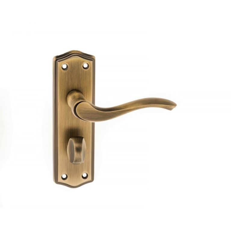 Atlantic Old English Warwick WC Lever Door Handle on Backplate in a brushed antique brass finish, featuring a curved lever and a round escutcheon with decorative plate and visible mounting screws.