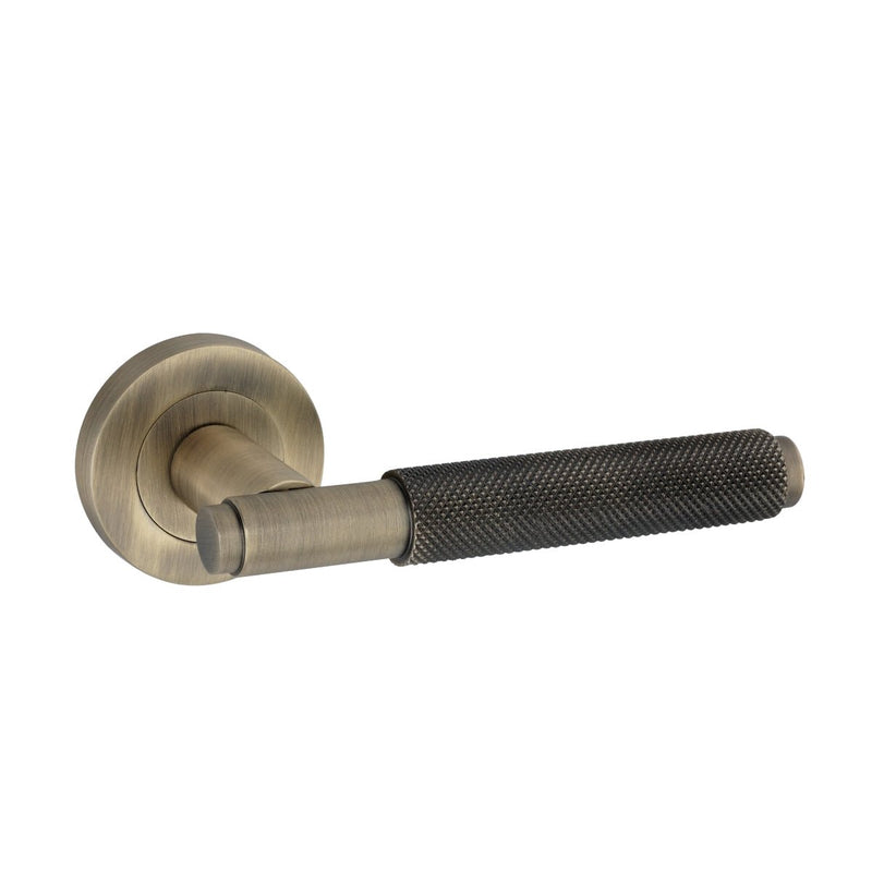 Spira Brass Connaught Lever on Rose with a brushed brass finish and a textured black handle. The lever features a round rose plate for mounting, providing a modern design suitable for doors.