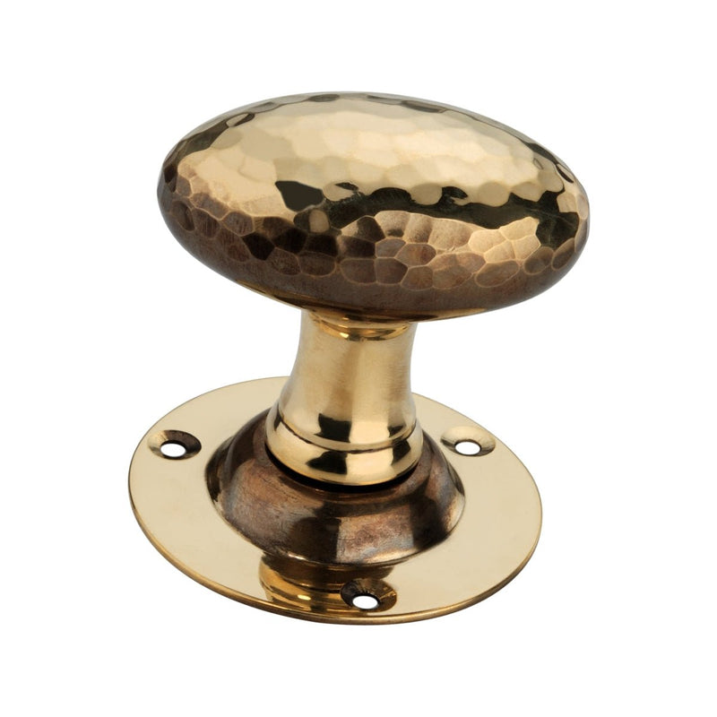 Spira Brass Hammered Oval Mortice Door Knob in a brushed brass finish, featuring a textured oval knob supported by a round base with four screw holes for installation.