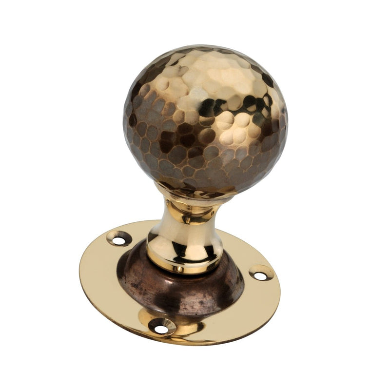 Spira Brass Hammered Ball Mortice Door Knob featuring a distinctive hammered finish on the round knob, mounted on a circular brass plate with four screw holes for installation.