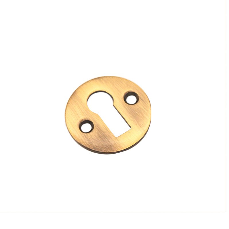 Spira Brass Victorian Key Hole Open Escutcheon in a brushed brass finish, featuring a round shape with a keyhole cutout and two mounting holes.
