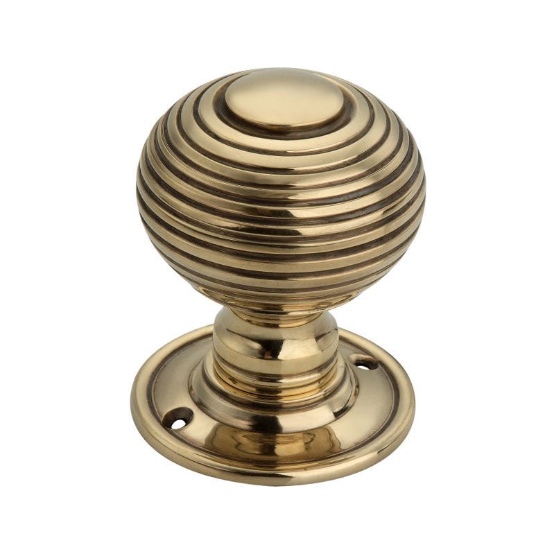 Spira Brass Beehive Large 60mm Mortice Door Knob in polished brass finish, featuring an intricately ribbed spherical design and circular rose base with screw holes for installation.