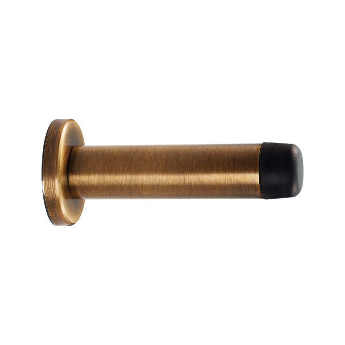 Carlisle Brass Wall Mounted Door Stop with Sprung option, featuring a cylindrical bronze body and a black rubber tip, designed for easy wall mounting.