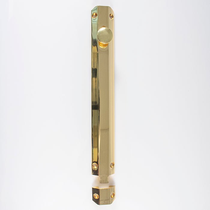 Carlisle Brass Surface Bolt in polished brass finish, featuring a long rectangular body with a round knob and multiple mounting holes for secure installation.