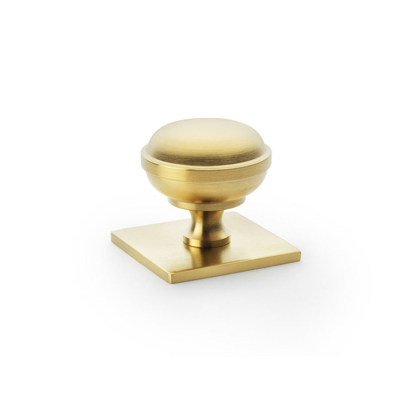 Alexander & Wilks Quantock Cupboard Knob on Square Backplate in brushed brass finish, featuring a rounded knob design mounted on a square backplate for easy grip.