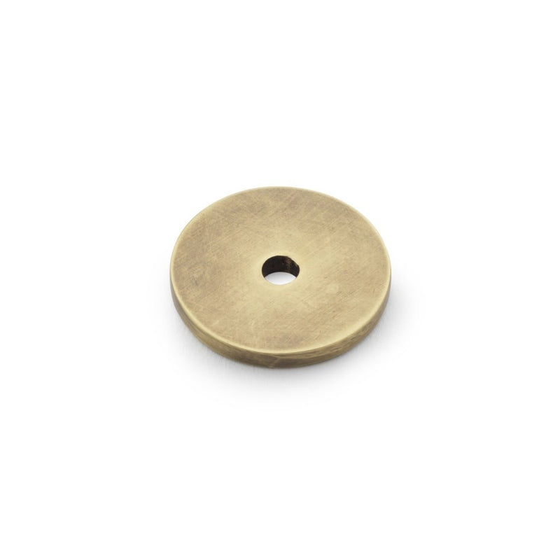 Alexander & Wilks Circular Backplate in a brushed brass finish, featuring a round design with a central hole. This metal accessory is suitable for various mounting applications.
