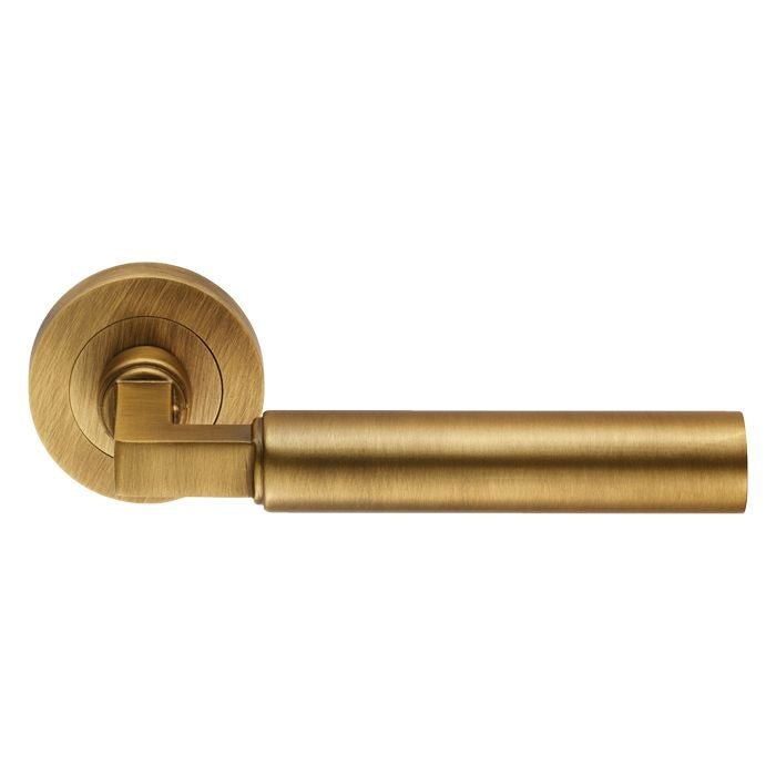 Carlisle Brass Amiata Lever On Round Rose in a brushed brass finish, featuring a cylindrical lever design attached to a round rose, suitable for various door styles.