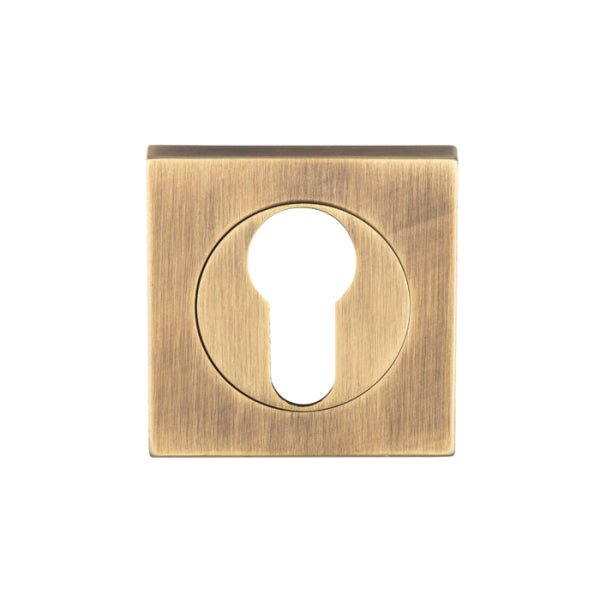 Carlisle Brass Square Escutcheons in an antique brass finish, featuring a square design with a circular keyhole cutout in the center. The surface has a brushed texture that complements the square shape.