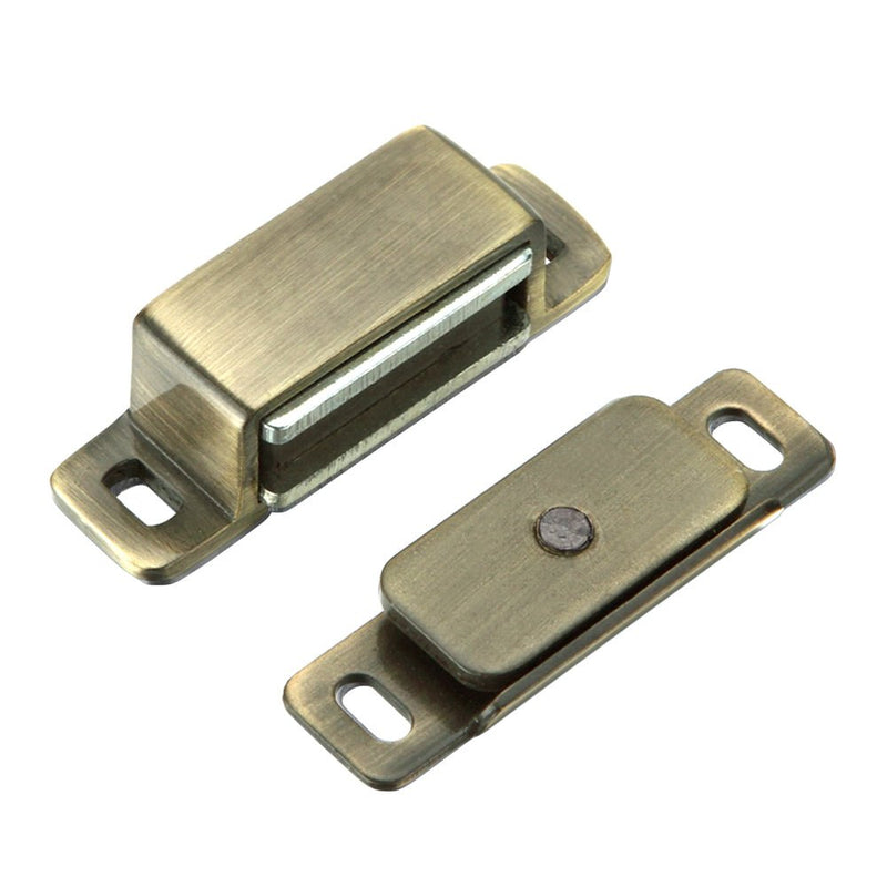 Zoo Hardware Magnetic Catch in an antique brass finish, featuring a rectangular shape with two mounting holes and a magnetic mechanism for secure closure.