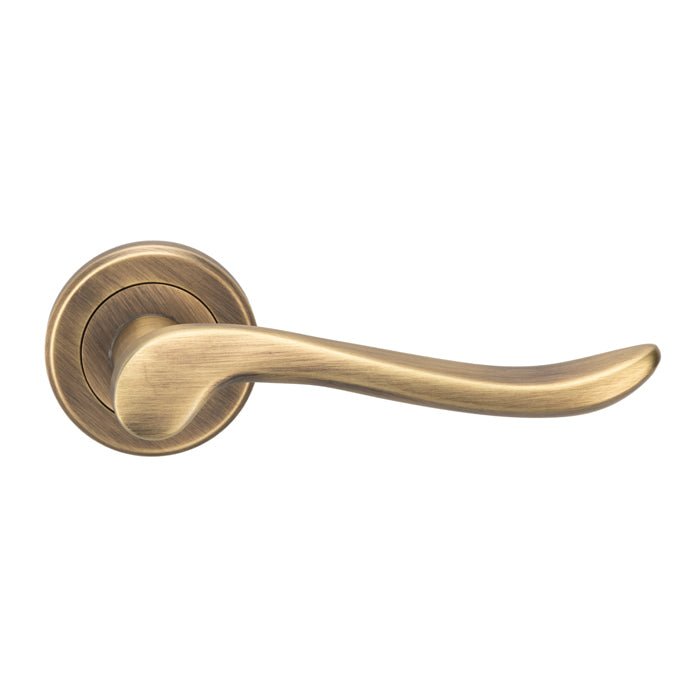 Carlisle Brass Verdun Lever On Rose in an antique brass finish, featuring a long, curved handle design and circular rose plate.