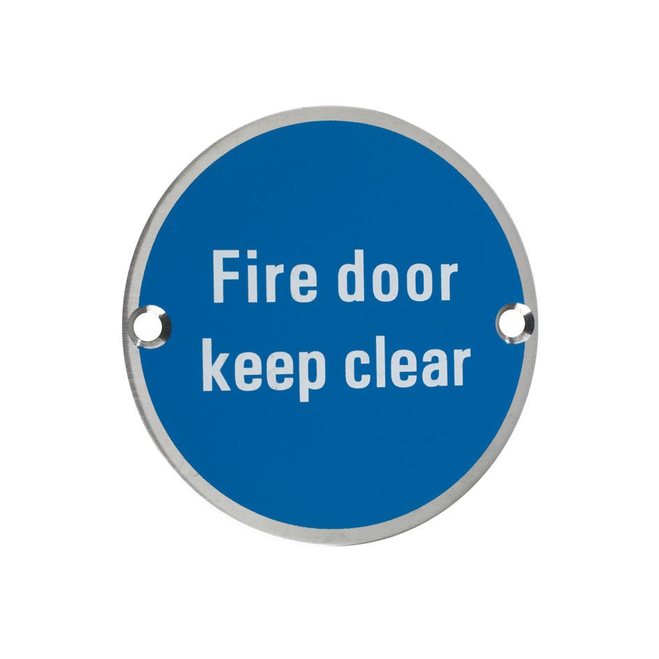 Zoo Hardware Fire Door Keep Clear Sign in blue with white text, featuring two holes for mounting. The circular sign serves to indicate that the area in front of a fire door must remain unobstructed.