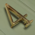 Brass bee Premium Floating Plain House Number ‘4’ in polished brass finish, featuring a sleek design with dimensional detailing and mounting prongs.