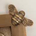 Brass bee Letterplate by Brass bee featuring a detailed bee design atop an antique brass finish with a textured background. The design includes an ornate bee with prominent wings and striped body, crafted from metal.