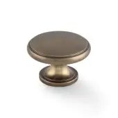 Alexander & Wilks Cambridge Round Cupboard Knob in antique brass finish, featuring a smooth round design with a tapered base.