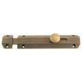 Carlisle Brass Surface Bolt in antique brass finish, featuring a sliding design with a round thumb knob and multiple mounting holes for secure installation.