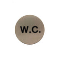 Atlantic Comercial Hardware round sign featuring a brushed metal finish with the letters "W.C." in bold black font. The sign is designed for restroom identification.