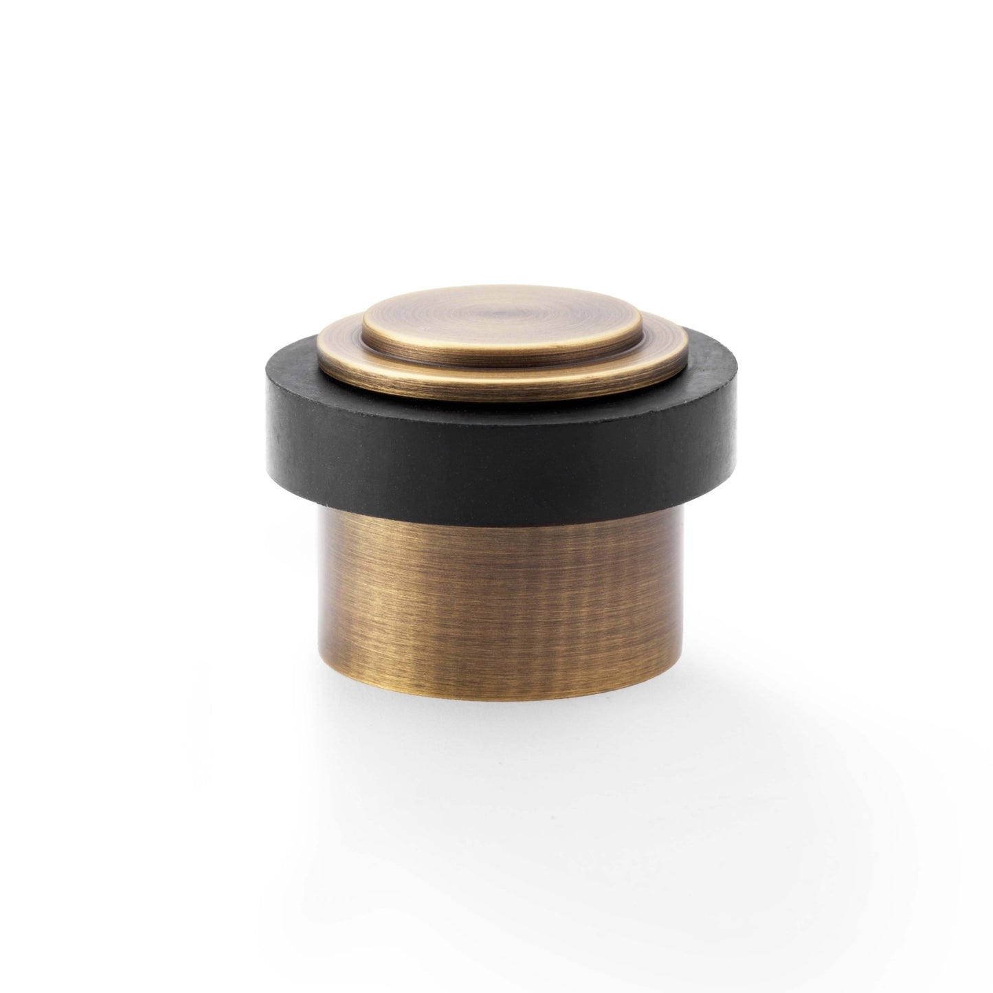 Alexander & Wilks Plain Floor Mounted Door Stop with a bronze finish and a black rubber ring, featuring a cylindrical shape with a flat top. This door stop is designed for floor mounting.