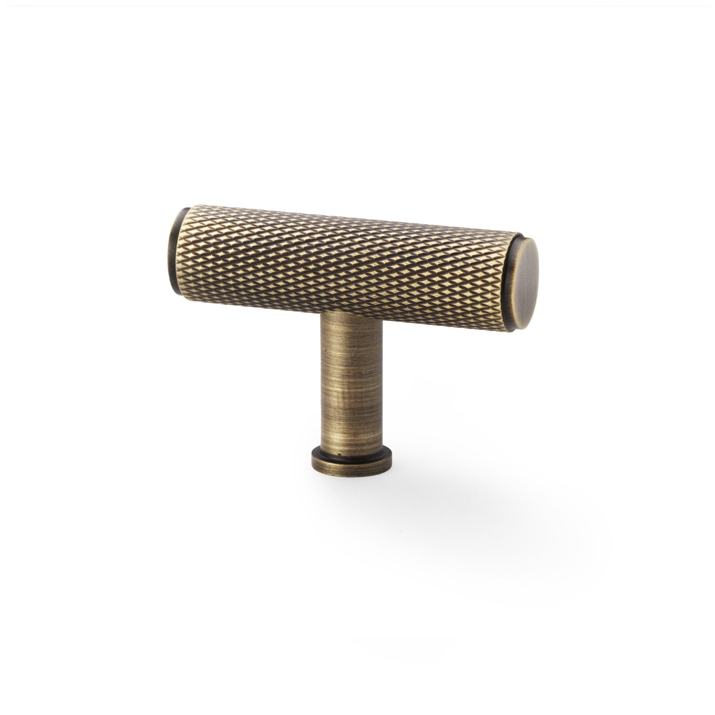 Alexander & Wilks Crispin Knurled T-Bar Cupboard Knob in an antique brass finish, featuring a textured knurled grip and a cylindrical base, designed for easy cabinet door access.