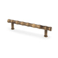 Alexander & Wilks Crispin Bamboo T-Bar Cupboard Pull Handle in a brushed antique brass finish, characterized by a textured, wavy design and two mounting posts.