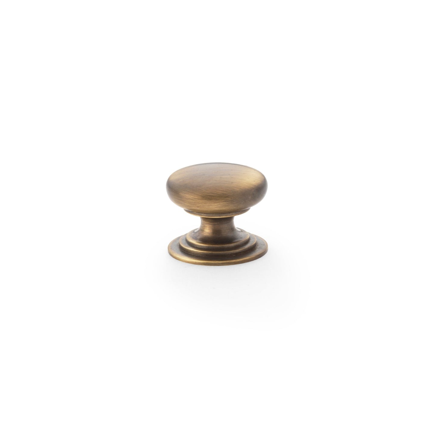 Alexander & Wilks Waltz Round Cupboard Knob on Stepped Rose in antique brass finish, featuring a smooth round shape and a stepped base for a classic design.