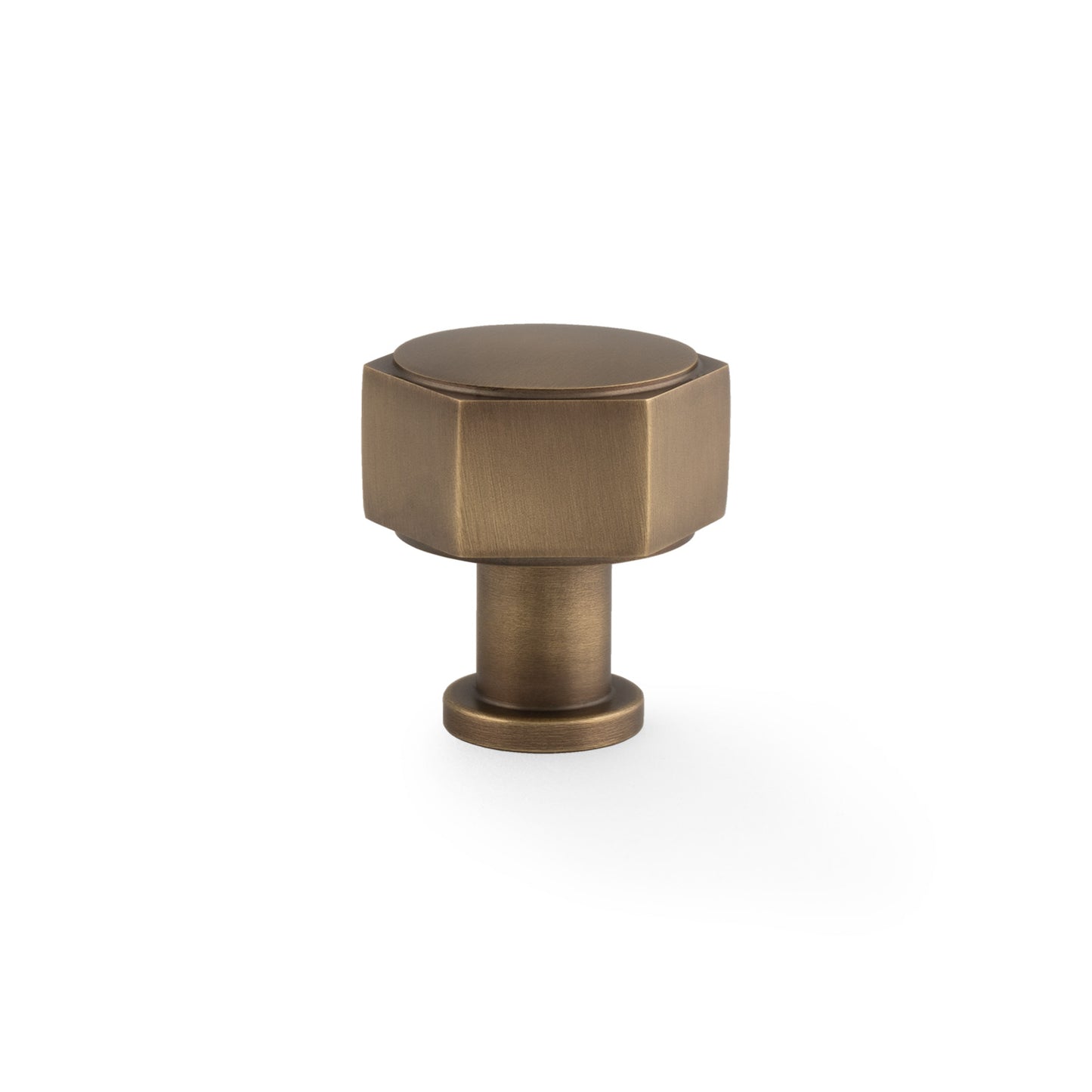 Alexander & Wilks Vesper Hex Cabinet Knob in antique brass, featuring a geometric hexagonal shape and a smooth surface, designed for use on cabinet doors and drawers.