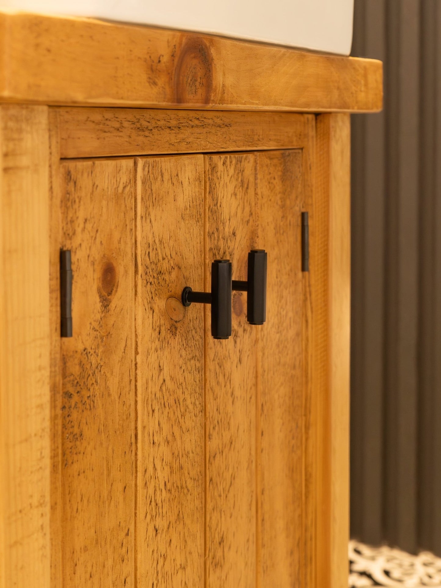Alexander & Wilks Vesper Hex T-Bar Cabinet Knob in black, showcasing a minimalist design mounted on a wooden cabinet with a natural finish.