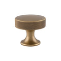 Alexander & Wilks Berlin Knurled Cupboard Knob in antique brass finish, featuring a textured surface for grip and a round top, mounted on a thick base.