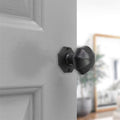 Spira Brass Octagonal Rim/Mortice Door Knob in a dark finish, featuring an octagonal shape and a smooth surface, mounted on a white door in a domestic setting.