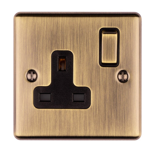 Eurolite Enhance Decorative 1 Gang Socket in antique finish, featuring a black power socket with two square openings and a toggle switch, set against a brushed metallic backdrop.