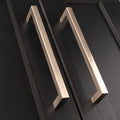 Carlisle Brass Block Handle in a brushed nickel finish, featuring a modern rectangular design with a smooth surface. The handle is shown on a dark wood cabinet, emphasizing its sleek lines and contemporary style.