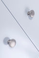 Carlisle Brass Oxford Knob in satin chrome finish, featuring a round shape and smooth surface, installed on a light blue cabinet.