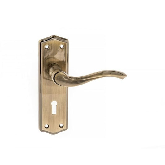 Atlantic Old English Warwick Key Lever Door Handle on Backplate in a brushed brass finish, featuring a curved lever and decorative backplate with a keyhole.