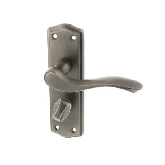 Atlantic Old English Warwick WC Lever Door Handle on Backplate in a brushed nickel finish, featuring a curved lever design and a matching thumb turn lock, mounted on a decorative backplate with rounded edges.