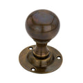 Spira Brass Ball Door Knob in an antique brass finish, featuring a round knob design and a matching circular base plate with mounting holes.