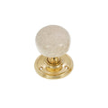 Spira Brass Crackled Porcelain Mortice Door Knob featuring a round crackled porcelain handle in cream color set on a polished brass base with visible screw holes.
