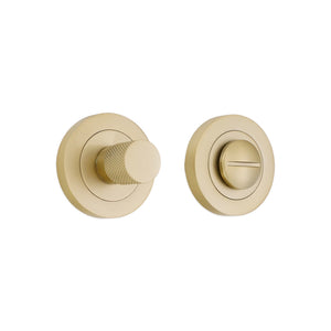 Spira Brass Connaught Knurled Turn & Release in brushed brass finish, featuring a textured turn knob and a flat release plate, both with circular backplates, offering a modern design for doors.