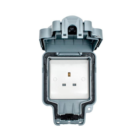 Eurolite Utility 1 Gang Unswitched Socket in grey with an open protective cover, featuring a white socket face with two square pin holes and a grounding pin. The design includes a weatherproof casing for outdoor installation.