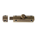 Carlisle Brass Surface Bolt in an antique brass finish, featuring a round knob for operation and a rectangular strike plate, designed for securing doors or gates.