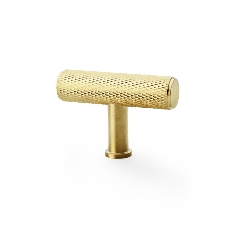 Alexander & Wilks Crispin Knurled T-Bar Cupboard Knob in a gold finish, featuring a textured knurled pattern on the cylindrical handle with a T-shaped design for easy grip.