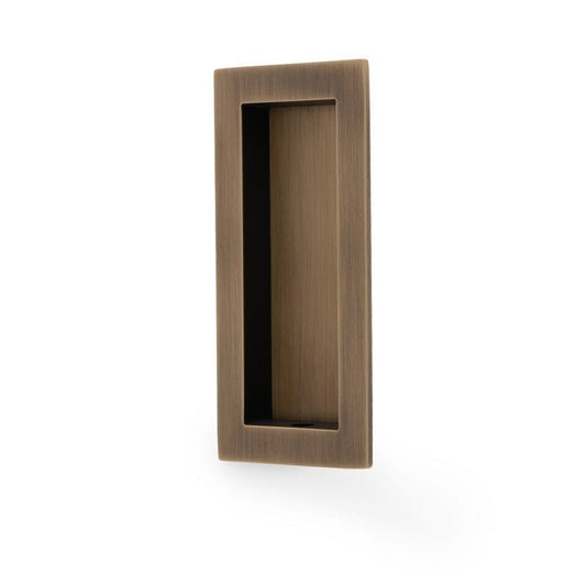 Alexander & Wilks Rectangular Flush Pull in an antique brass finish, featuring a simple rectangular design with a recessed handle for easy gripping.